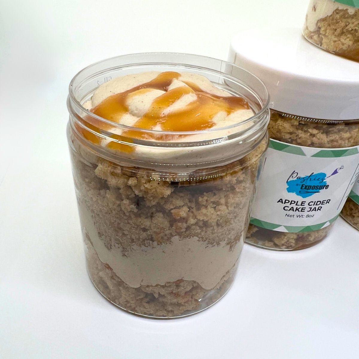 Jar of apple cider cake with a visible brand label on a white background