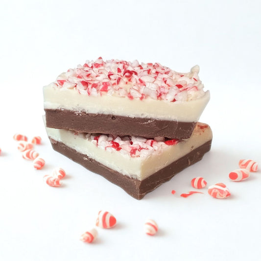 Stack of layered candy bars with peppermint pieces on a white background