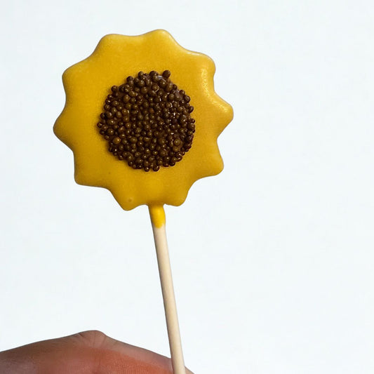 Yellow flower-shaped lollipop with a brown center on a white background